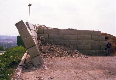 Betonblocksteinwand, bei der ein Abschnitt umgefallen ist und der benachbarte Abschnitt noch steht